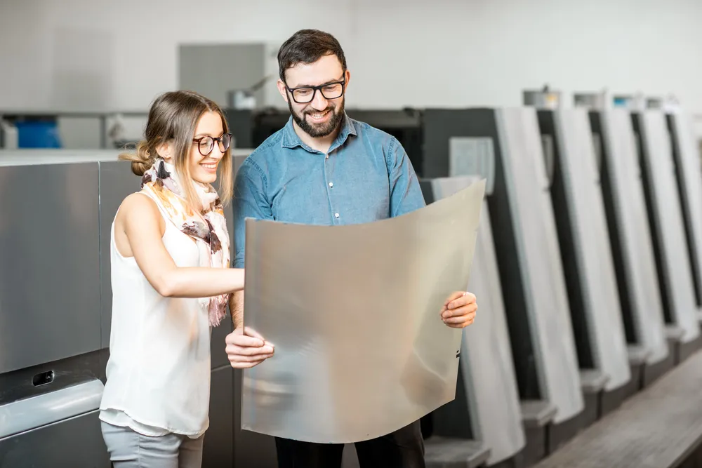Fotografía de dos Colaboradores de Artes Gráficas Carnevali revisando la publicidad impresa que elaboraron.
